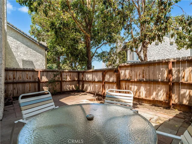 a backyard of a house with barbeque oven table and chairs