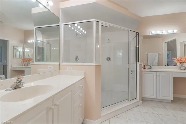 a bathroom with a shower sink vanity and mirror