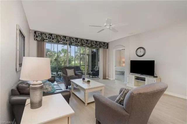 a living room with furniture a flat screen tv and a large window