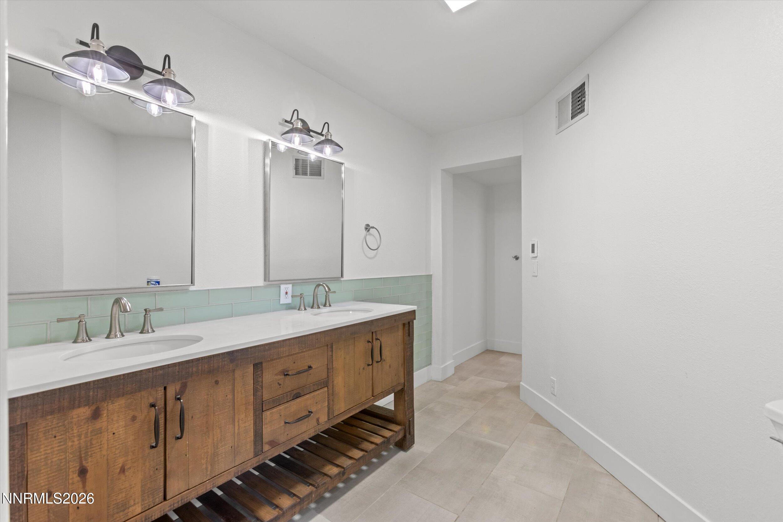 2725 West Lake Ridge Shores Reno, NV 89519 - Photo 35 of 49 a bathroom with a double vanity sink and a mirror
