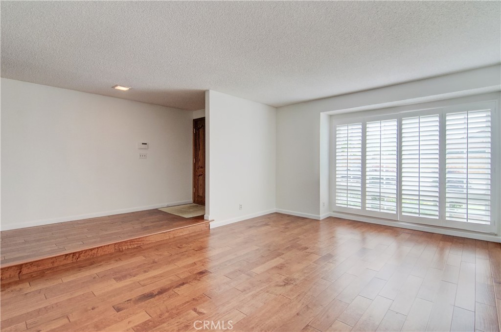 10091 Saltair Drive Cypress, CA 90630 - Photo 11 of 42 a view of an empty room with wooden floor and a window
