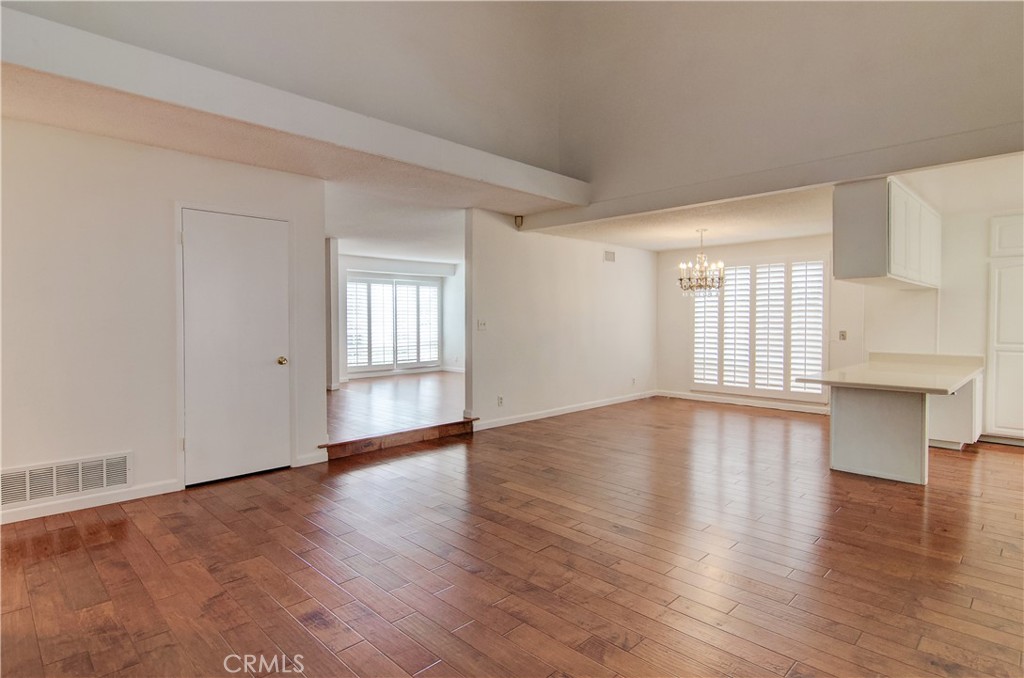 10091 Saltair Drive Cypress, CA 90630 - Photo 16 of 42 an empty room with wooden floor and windows