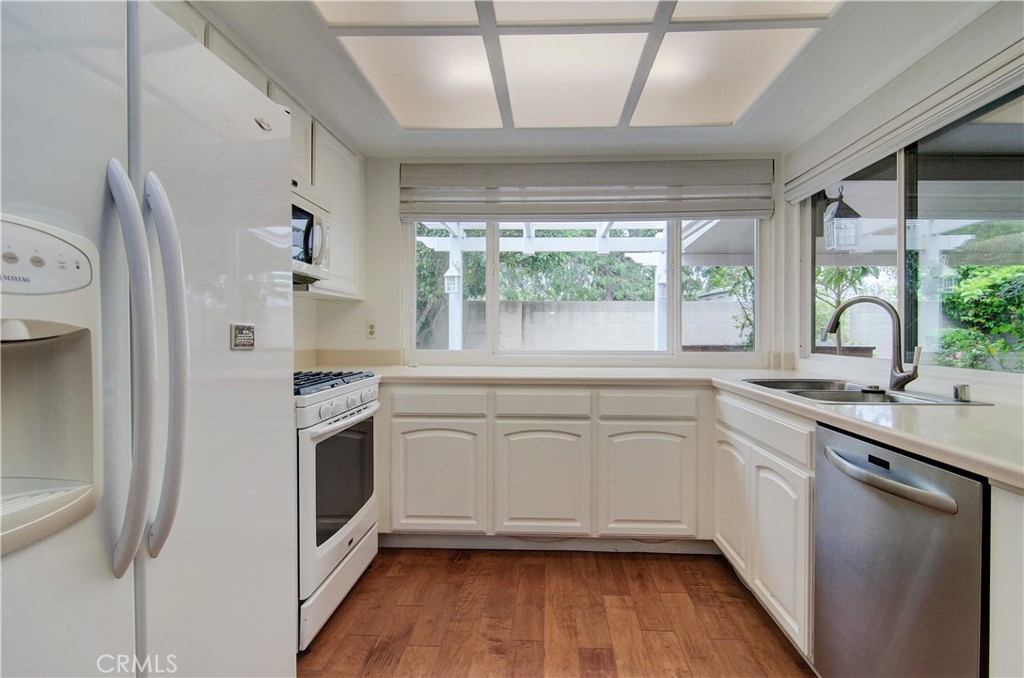 10091 Saltair Drive Cypress, CA 90630 - Photo 20 of 42 a kitchen with stainless steel appliances white cabinets a sink and a large window