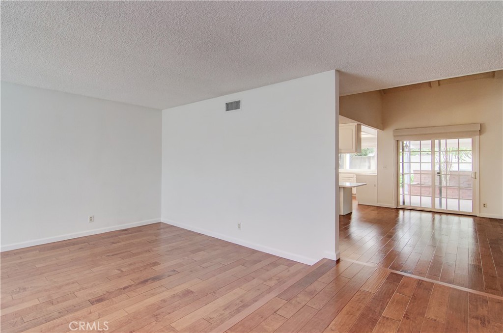 10091 Saltair Drive Cypress, CA 90630 - Photo 9 of 42 a view of an empty room with wooden floor and a window