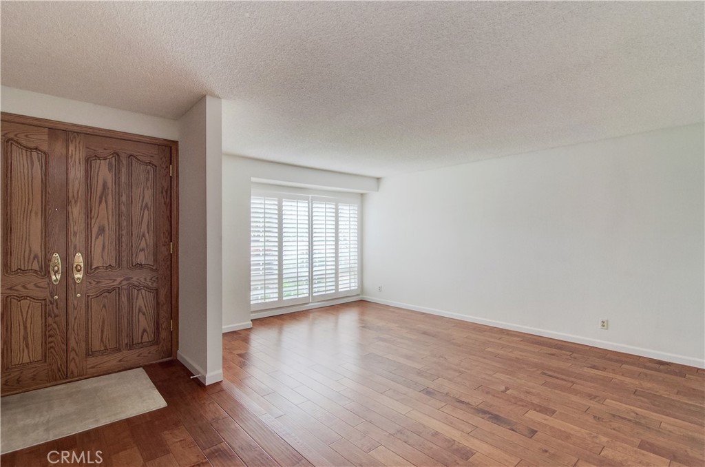10091 Saltair Drive Cypress, CA 90630 - Photo 10 of 42 an empty room with wooden floor and windows
