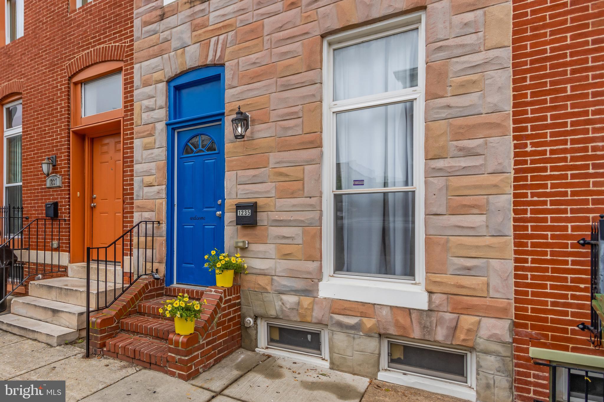 a brick building with a window and potted plants