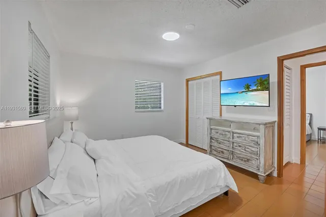 a bedroom with a bed a dresser and a window