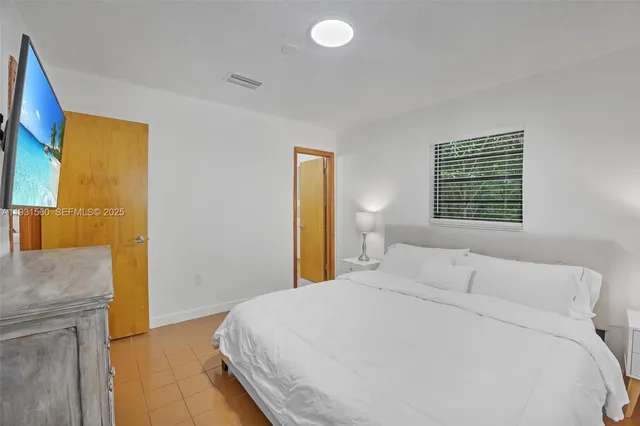 a bedroom with a bed and a flat screen tv