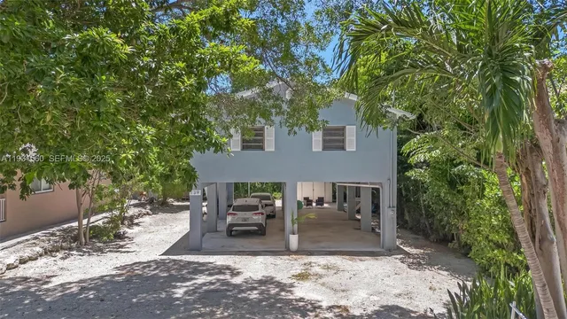 a view of a patio with table and chairs and potted plants with large tree