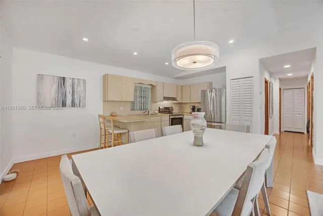 a kitchen with stainless steel appliances granite countertop a sink dishwasher and a refrigerator with wooden floor