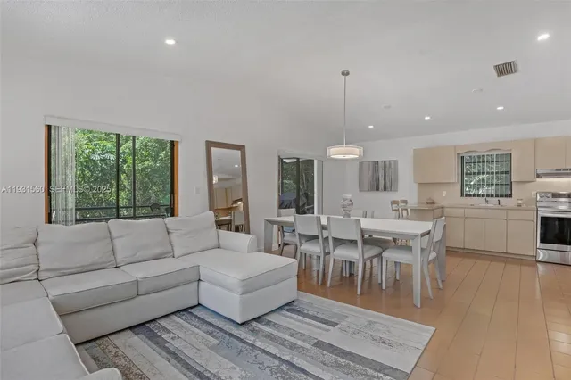 a living room with furniture a table and a large window