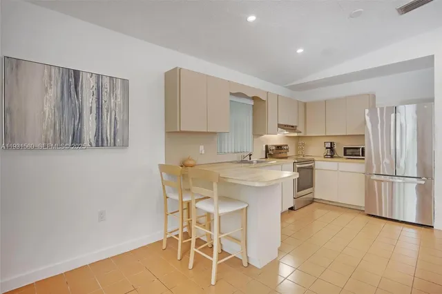 a kitchen with a sink a counter top space stainless steel appliances and cabinets