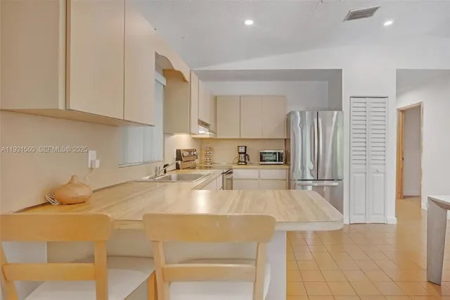 a kitchen with stainless steel appliances granite countertop a sink a refrigerator and a stove