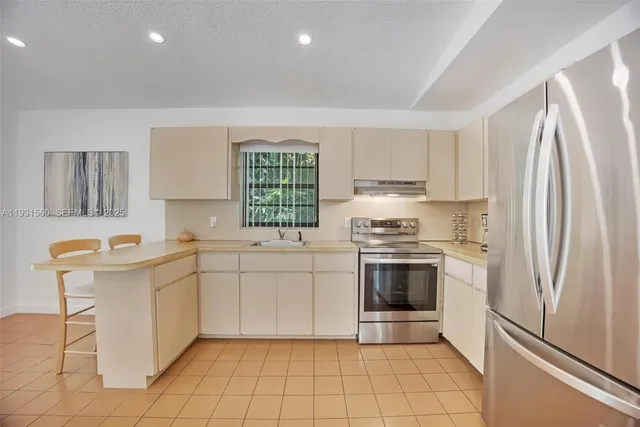 a kitchen with stainless steel appliances a stove a sink and a refrigerator