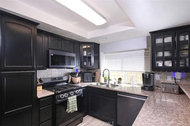 a kitchen with stainless steel appliances granite countertop a stove sink and cabinets