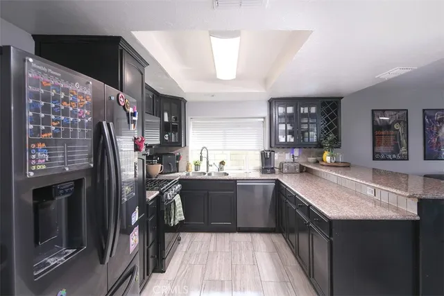 a kitchen with stainless steel appliances granite countertop a sink and wooden cabinets