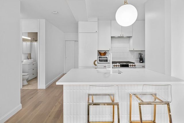a kitchen with cabinets and wooden floor