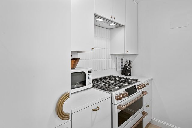 a kitchen with a stove and a white cabinet
