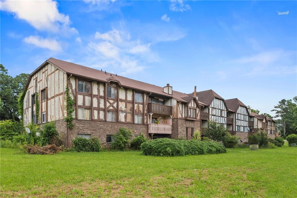 a view of a big house with a big yard and large trees