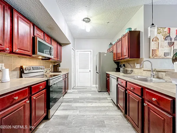 a kitchen with stainless steel appliances granite countertop a stove a sink dishwasher and a refrigerator
