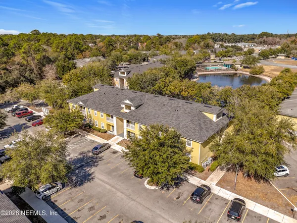 an aerial view of residential houses with outdoor space and trees