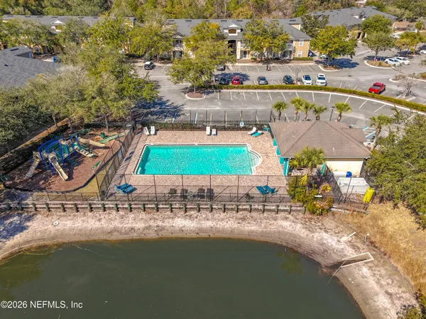 an aerial view of residential houses with outdoor space and swimming pool