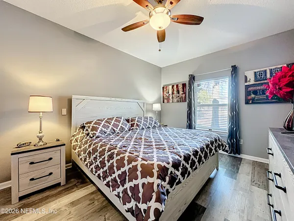 a bedroom with a bed and painting on the wall