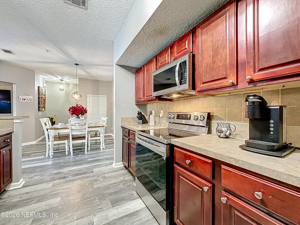 a kitchen with stainless steel appliances granite countertop a stove top oven a sink dishwasher and cabinets with wooden floor