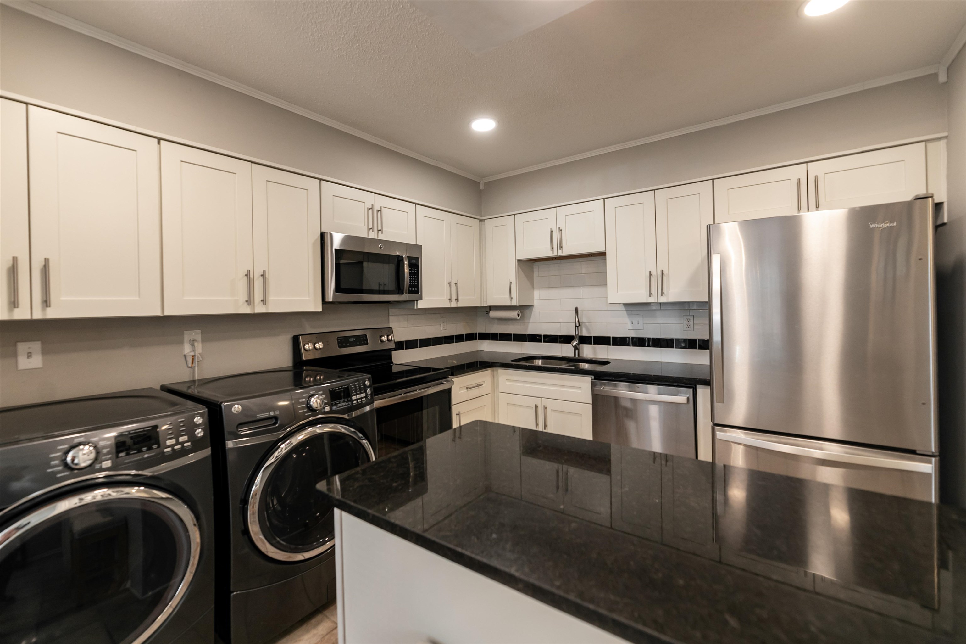 871 South Yates Road, Unit 1 Memphis, TN 38120 - Photo 7 of 23 a kitchen with a refrigerator a microwave a sink and cabinets