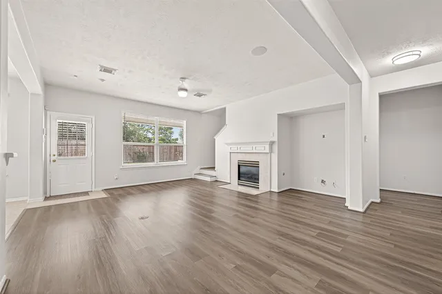 a view of a room with wooden floor and white walls