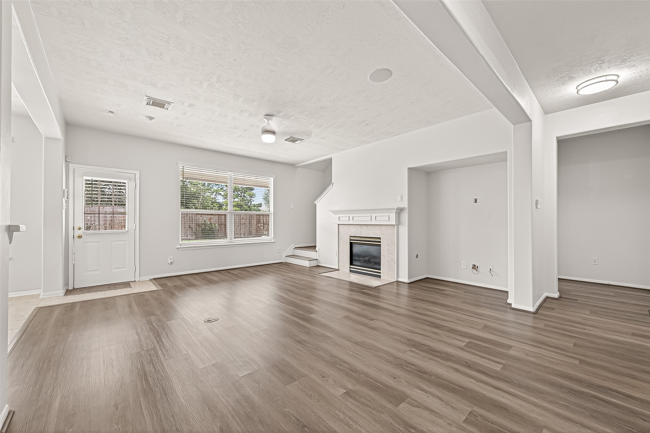 19343 Dickson Park Drive Spring, TX 77373 - Photo 12 of 49 an empty room with wooden floor fireplace and windows