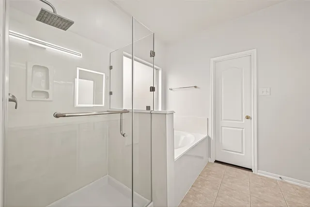 a view of an empty room with wooden floor and a ceiling fan