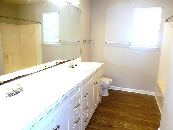 a bathroom with a sink a toilet and a window