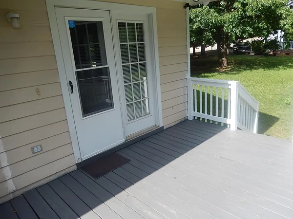 a view of front door deck and yard