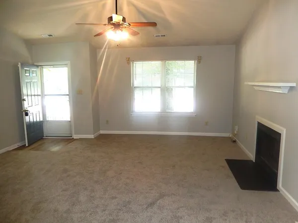 an empty room with windows and fireplace