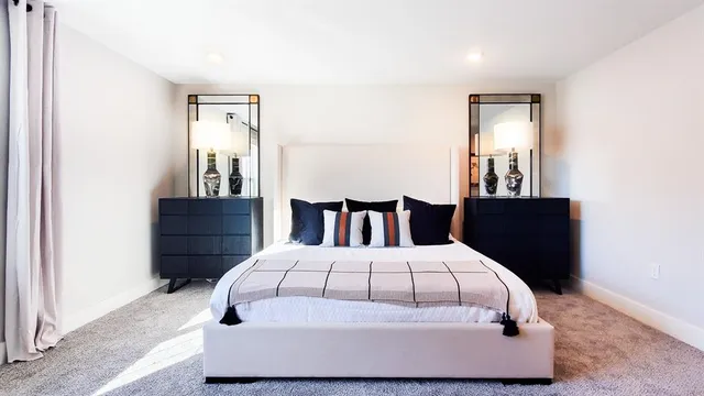 a large bed sitting in a bedroom next to a wooden cabinet