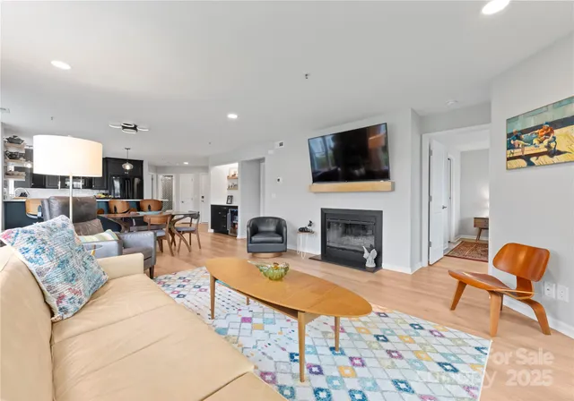 a living room with furniture a fireplace and flat screen tv