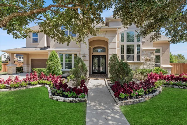 a front view of a house with a yard and fountain in middle
