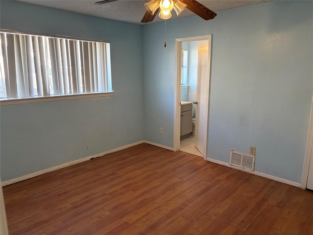 13360 Southview Lane Dallas, TX 75240 - Photo 14 of 26 an empty room with wooden floor and windows