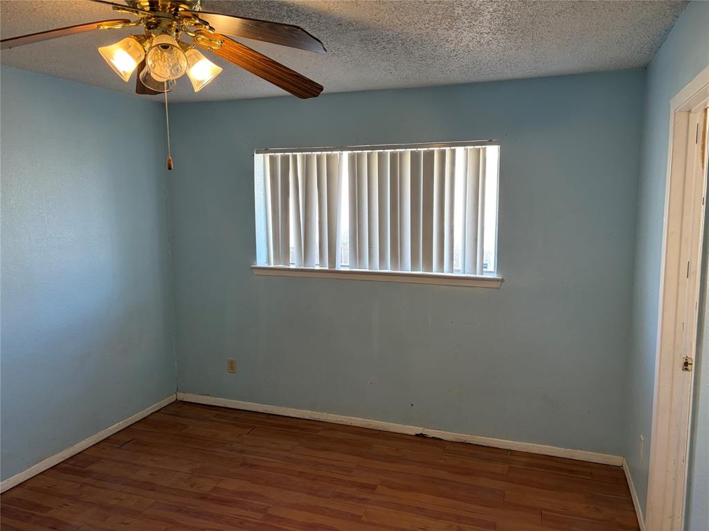 13360 Southview Lane Dallas, TX 75240 - Photo 15 of 26 an empty room with wooden floor and windows
