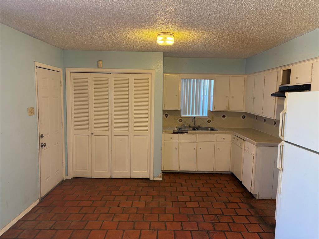 13360 Southview Lane Dallas, TX 75240 - Photo 7 of 26 a kitchen with a refrigerator and white cabinets
