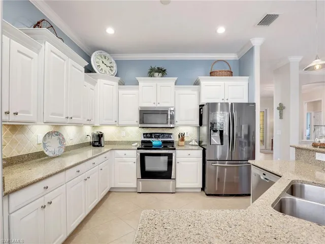 a kitchen with granite countertop a sink stainless steel appliances and cabinets