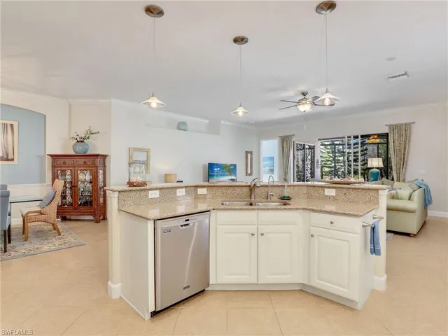 a kitchen with white cabinets and sink