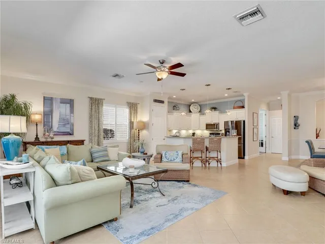a living room with furniture kitchen view and a chandelier