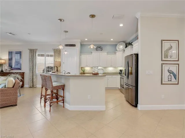 a kitchen with stainless steel appliances kitchen island granite countertop a refrigerator and cabinets