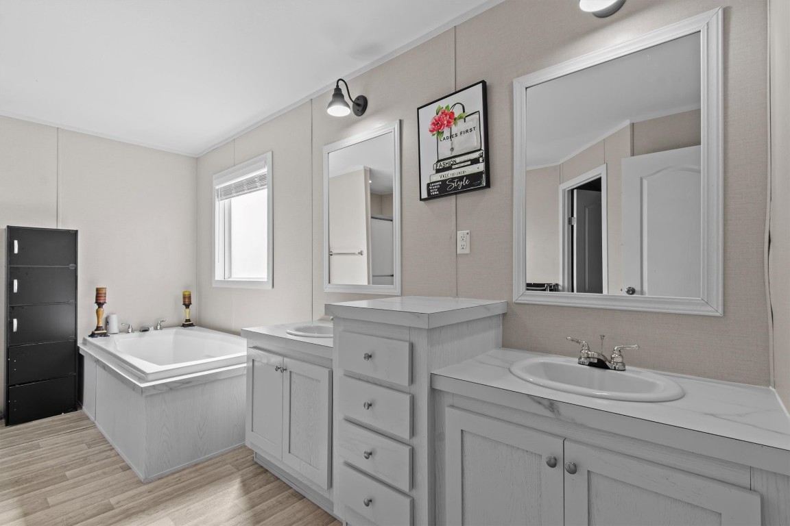 480 Grandpa Road Lockhart, TX 78644 - Photo 11 of 32 a bathroom with a sink double vanity granite tub and a window