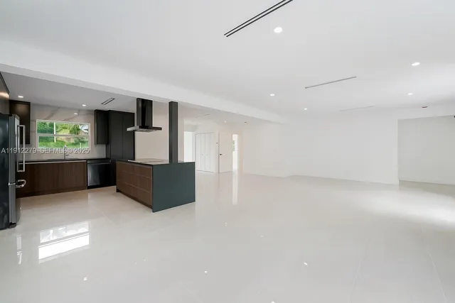 a large room with a large window and a kitchen counter top