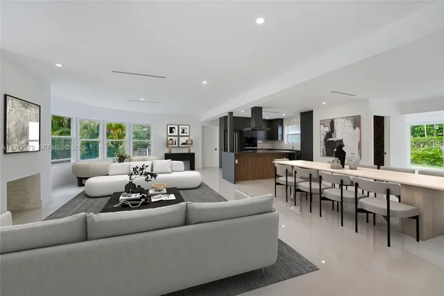 a living room with furniture kitchen view and a large window
