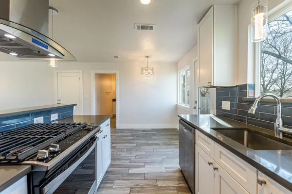 a kitchen with stainless steel appliances granite countertop a sink stove and cabinets