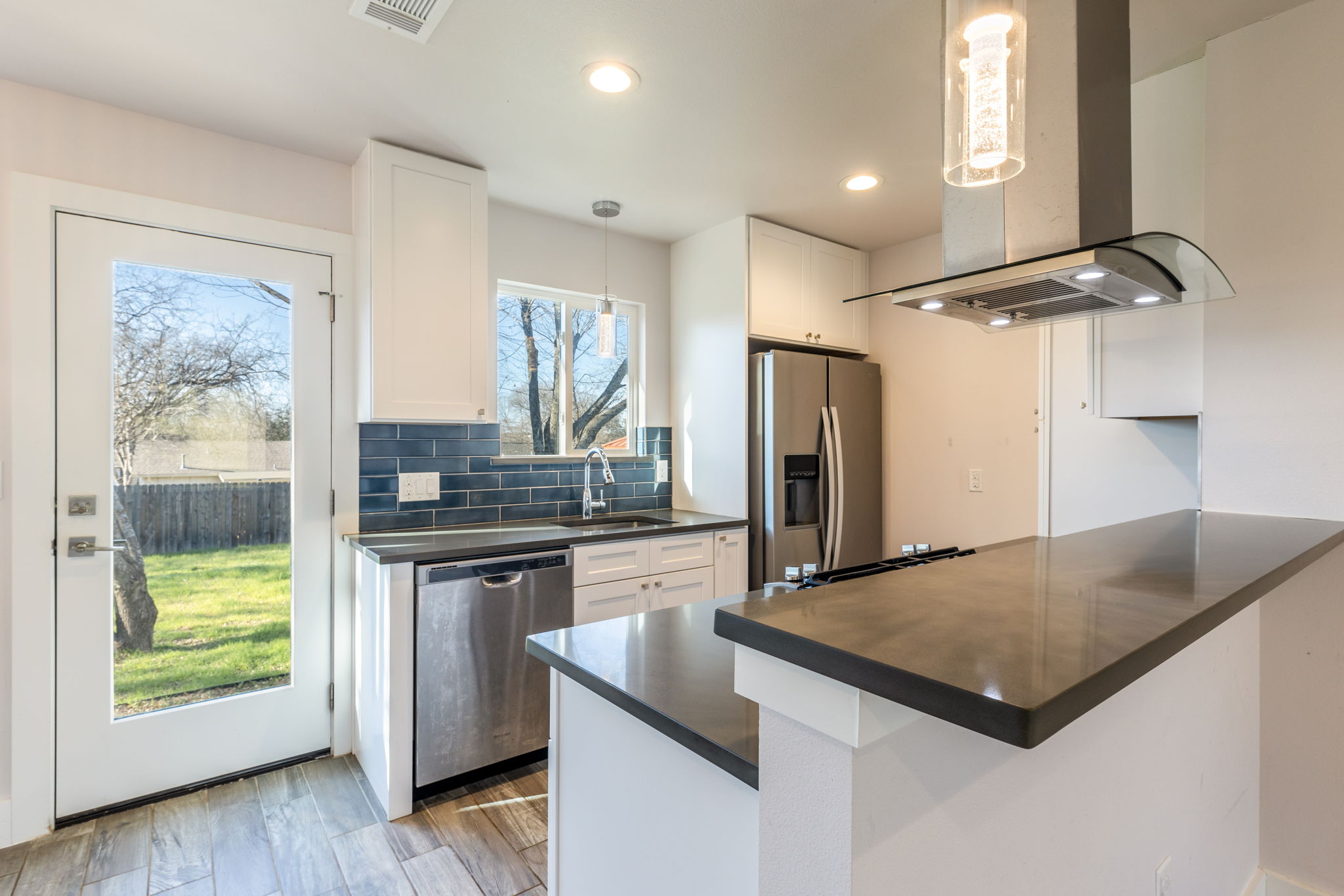 8410 Romney Road Austin, TX 78748 - Photo 13 of 35 Kitchen featuring white cabinetry, island range hood, a peninsula, pendant lighting, and stainless steel appliances
